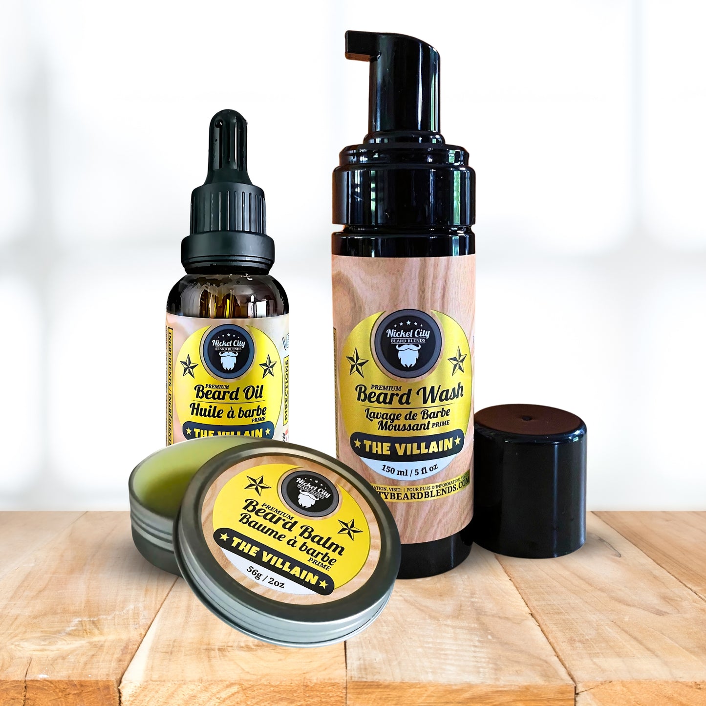 Set of beard care products including oil, wash, and balm on a wooden surface with a white background.