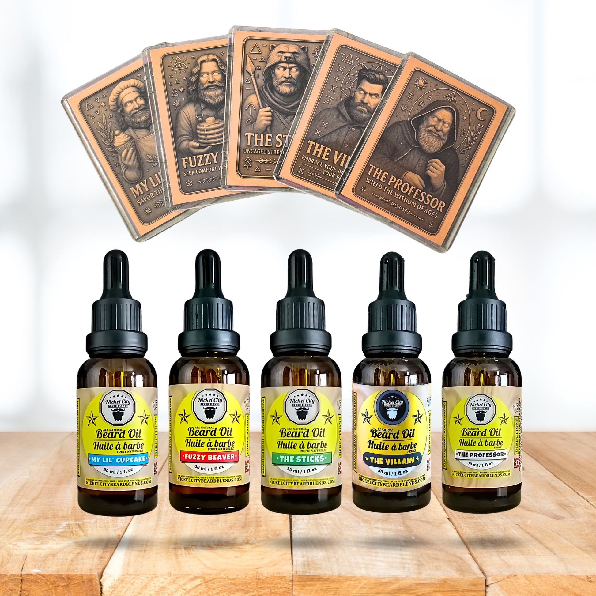 Five bottles of beard oil with labels and five playing card-sized product cards on a wooden surface.