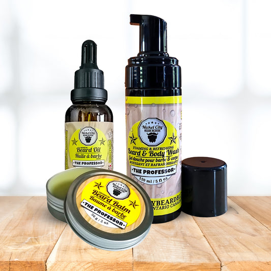 Set of beard care products including oil, balm, and wash on a wooden surface with a white background.