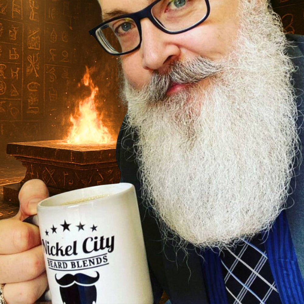 Dr. Christopher Schneider holding a mug labeled 'Nickel City Beard Blends' in front of a fire forge.