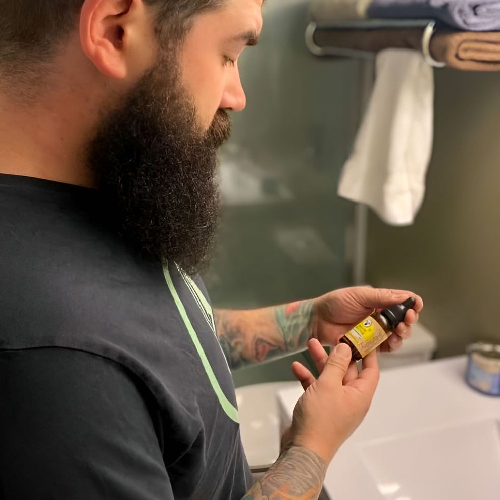 Bearded Man Holding a Beard Oil From Nickel City Beard Blends 