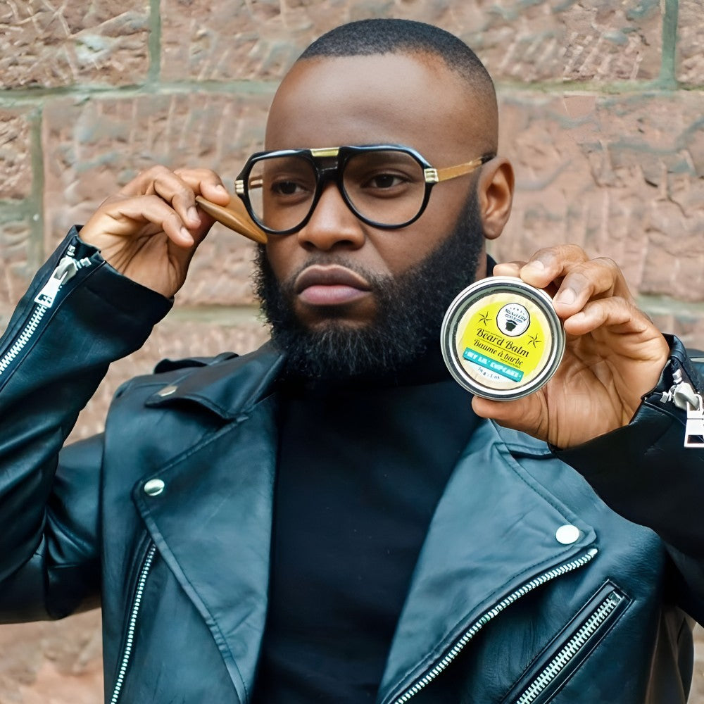 Bearded man holding beard balm and a wooden beard comb