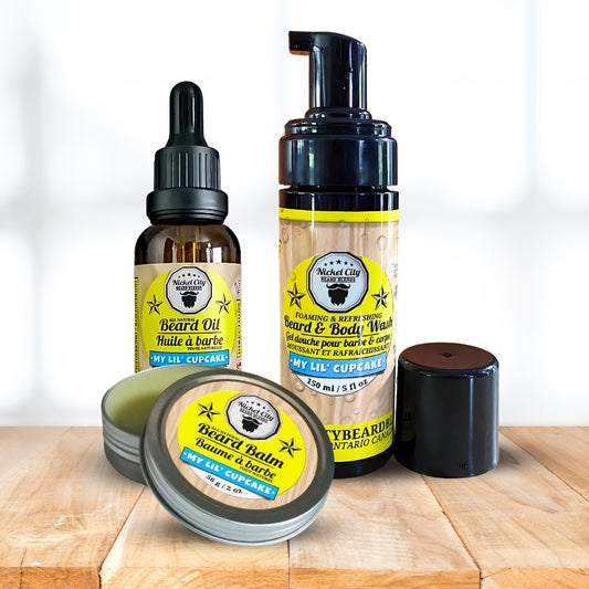 Collection of beard care products including oil, balm, and wash on a wooden surface with a white background.